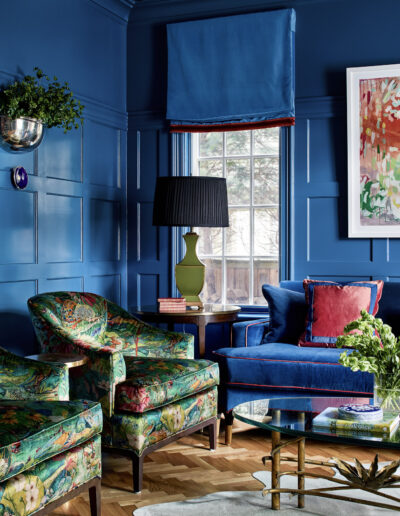 A living room with blue walls and green furniture.