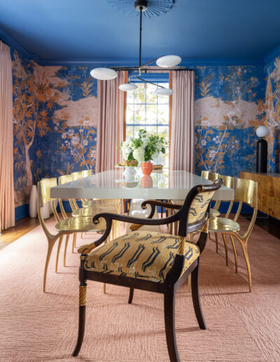 A dining room with blue walls and yellow chairs.