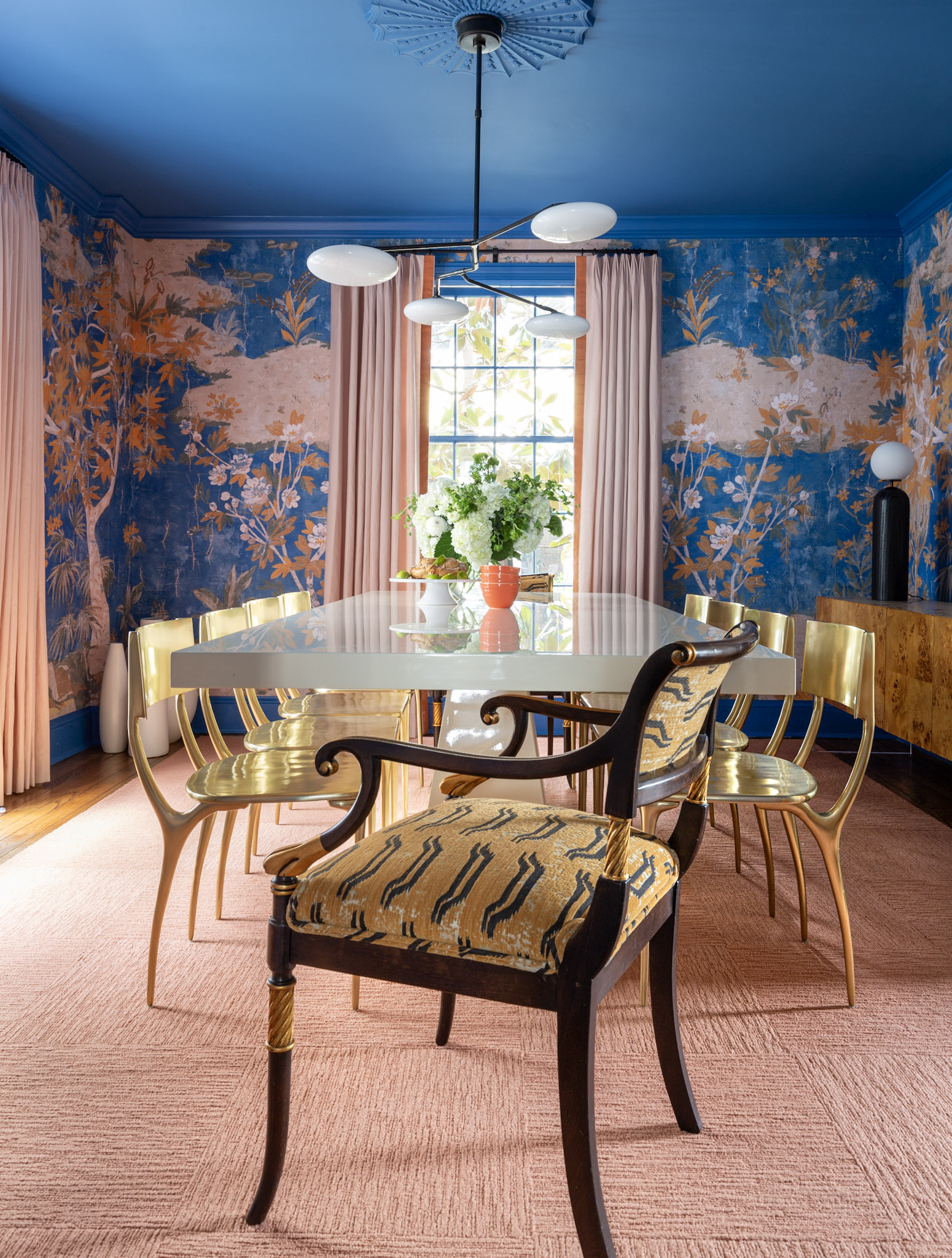 A dining room with blue walls and yellow chairs.