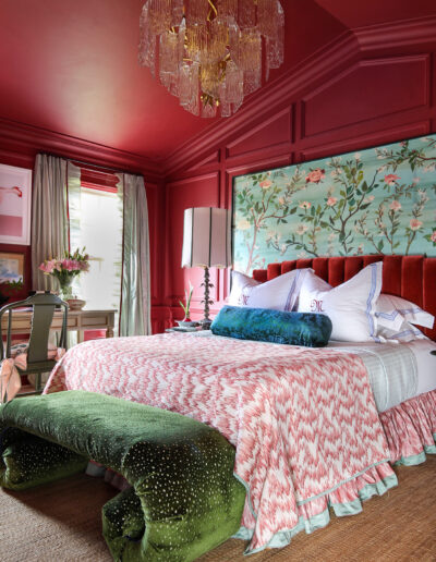 A bedroom with red walls and green furniture.