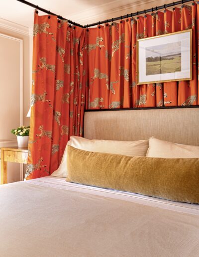 A bed room with a red curtain and a brown headboard