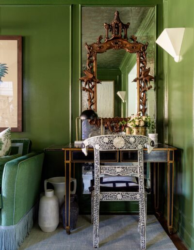 A green room with a mirror and chair