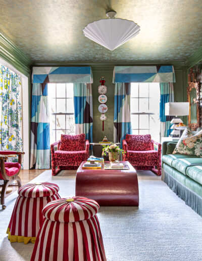 A living room with two red chairs and a couch