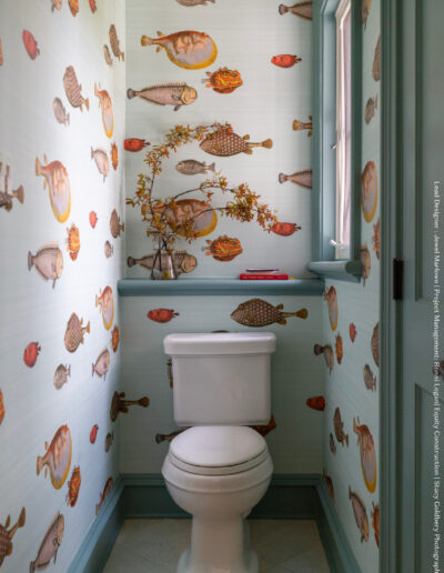 A bathroom with fish wallpaper and a toilet.